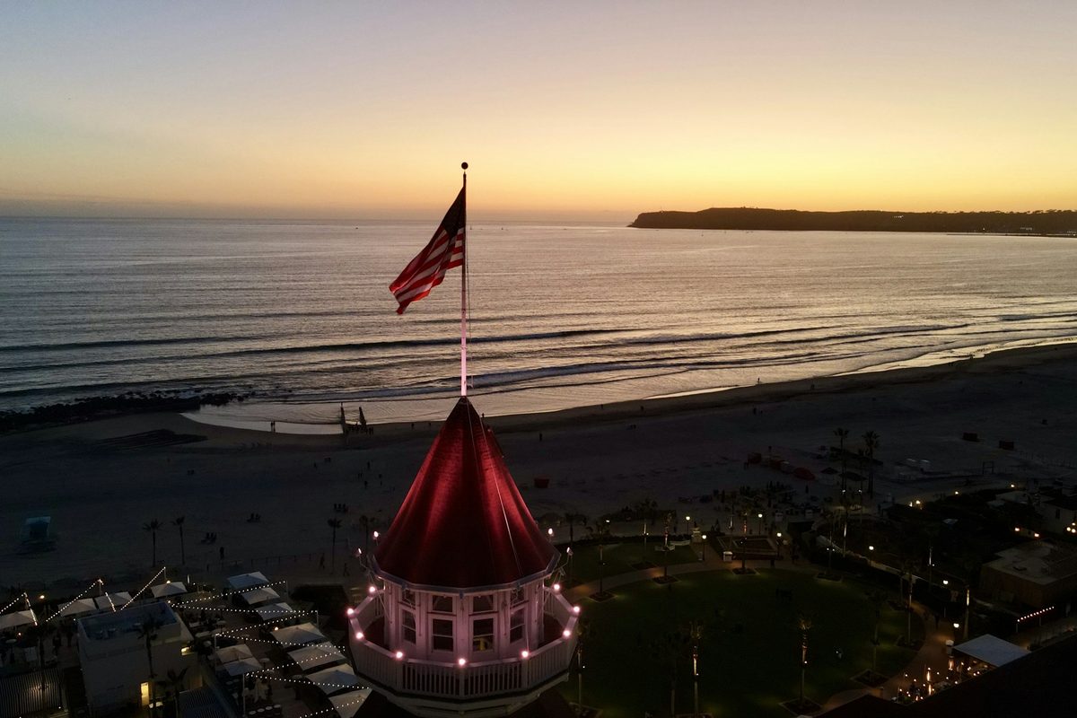 The Hotel del Coronado roof and flag above Coronado Beach