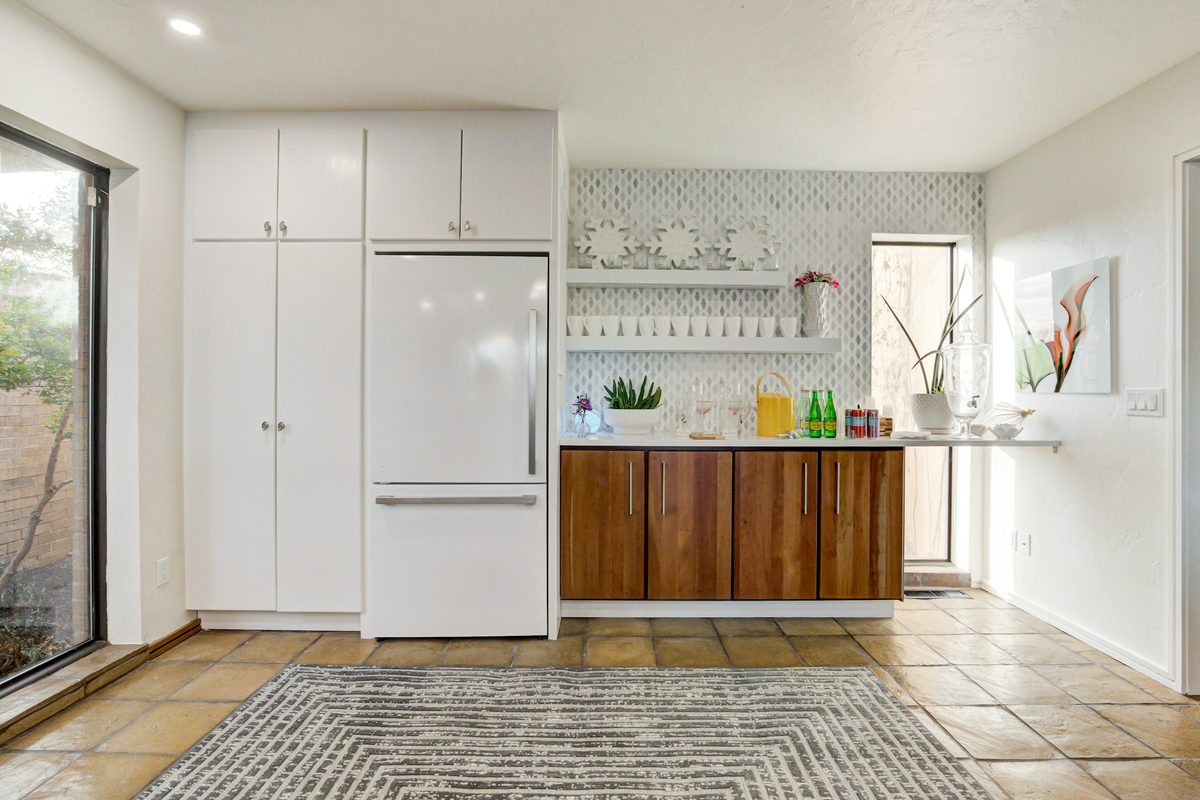 Built-in refrigerator set flush into white kitchen cabinetry